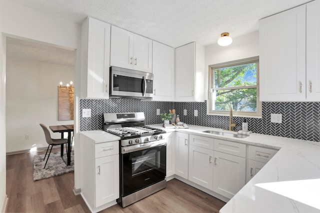 8139 Storrow Dr, Westerville, OH 43081 - kitchen featuring stainless steel appliances, light wood finished floors, white cabinets, and a textured ceiling