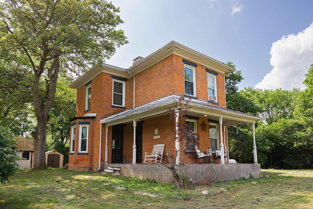 1871 Galloway Rd, Galloway, OH 43119 - view of front of house with covered porch, brick siding, and a storage shed