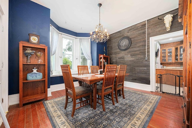 1871 Galloway Rd, Galloway, OH 43119 - dining room with an accent wall, a chandelier, wooden walls, and wood finished floors
