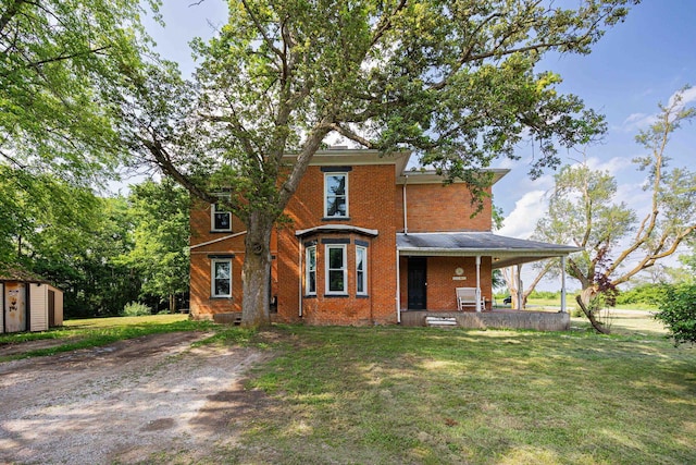 1871 Galloway Rd, Galloway, OH 43119 - rear view of house with brick siding, a lawn, a porch, and a storage unit