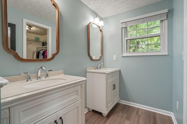 712 Suntree Dr, Westerville, OH 43081 - full bathroom featuring a textured ceiling, wood finished floors, two vanities, and a spacious closet