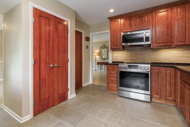 2006 Kentwell Rd, Upper Arlington, OH 43221 - kitchen featuring appliances with stainless steel finishes, dark countertops, decorative backsplash, recessed lighting, and light tile patterned floors