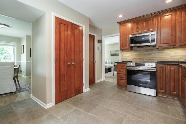 2006 Kentwell Rd, Upper Arlington, OH 43221 - kitchen featuring stainless steel appliances, dark countertops, tasteful backsplash, recessed lighting, and brown cabinetry