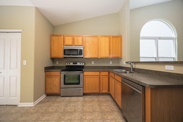 5654 Caledonia Dr, Westerville, OH 43081 - kitchen with stainless steel appliances, dark countertops, lofted ceiling, and brown cabinetry