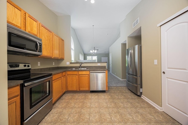 5654 Caledonia Dr, Westerville, OH 43081 - kitchen featuring stainless steel appliances, a peninsula, a chandelier, dark countertops, and lofted ceiling