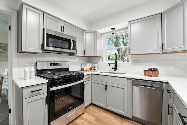 1360 Langston Dr, Columbus, OH 43220 - kitchen featuring appliances with stainless steel finishes, gray cabinets, light countertops, and tasteful backsplash