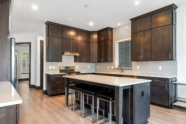 954 Hudson Xing, Columbus, OH 43212 - kitchen with under cabinet range hood, dark brown cabinetry, light wood-style floors, appliances with stainless steel finishes, and recessed lighting