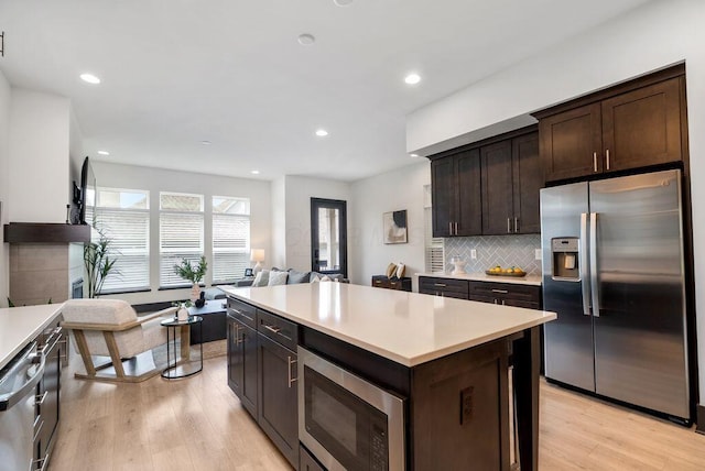 954 Hudson Xing, Columbus, OH 43212 - kitchen with stainless steel appliances, light countertops, dark brown cabinets, light wood-style floors, and open floor plan