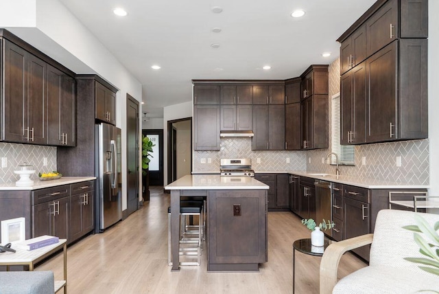 954 Hudson Xing, Columbus, OH 43212 - kitchen with stainless steel appliances, dark brown cabinets, a kitchen island, tasteful backsplash, and light wood-style floors