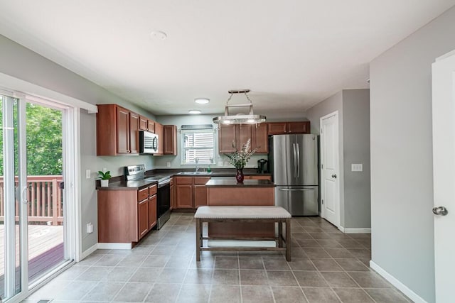 929 Preble Dr, Blacklick, OH 43004 - kitchen with stainless steel appliances, dark countertops, light tile patterned flooring, and a kitchen island