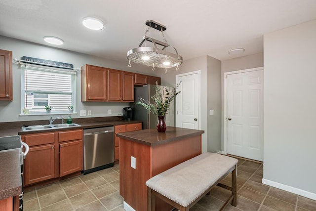 929 Preble Dr, Blacklick, OH 43004 - kitchen with stainless steel appliances, dark countertops, light tile patterned floors, a kitchen island, and brown cabinetry