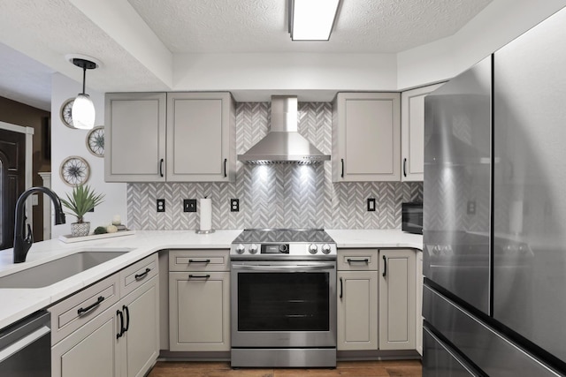 215 Barb Ct, Heath, OH 43056 - kitchen with stainless steel appliances, wall chimney exhaust hood, gray cabinets, a textured ceiling, and decorative backsplash
