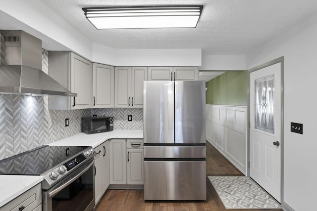 215 Barb Ct, Heath, OH 43056 - kitchen featuring stainless steel appliances, wall chimney exhaust hood, gray cabinetry, dark wood-type flooring, and a wainscoted wall