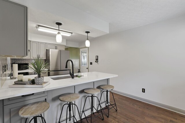 215 Barb Ct, Heath, OH 43056 - kitchen featuring gray cabinetry, freestanding refrigerator, a peninsula, dark wood finished floors, and backsplash
