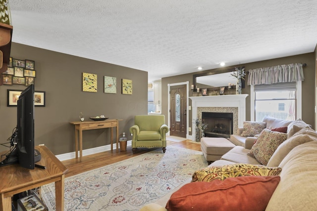 215 Barb Ct, Heath, OH 43056 - living room with a textured ceiling, wood finished floors, a tiled fireplace, and recessed lighting