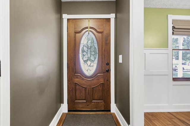 215 Barb Ct, Heath, OH 43056 - foyer with wood finished floors, a decorative wall, and wainscoting