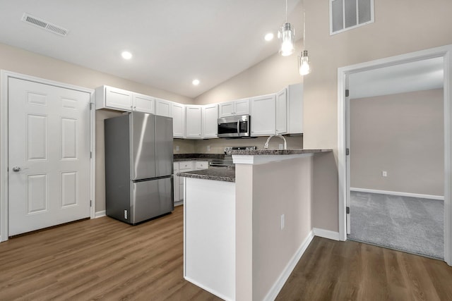 752 Whitetail Lp, Newark, OH 43055 - kitchen with appliances with stainless steel finishes, a peninsula, white cabinets, wood finished floors, and vaulted ceiling