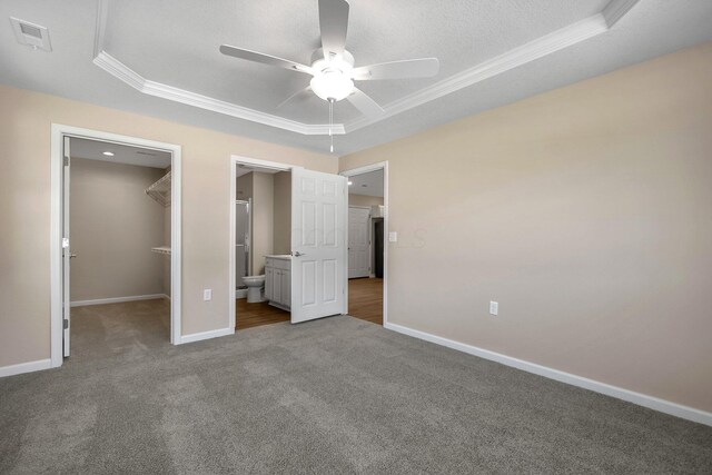 752 Whitetail Lp, Newark, OH 43055 - unfurnished bedroom with a tray ceiling, ornamental molding, carpet floors, a walk in closet, and a closet
