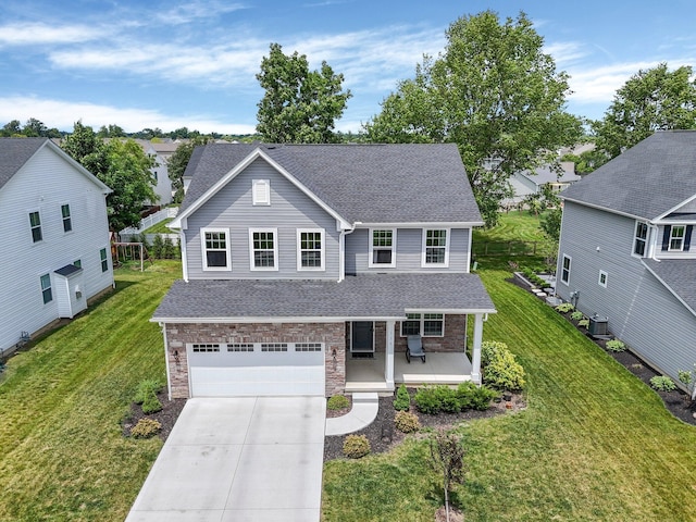 336 Onyx Ln, Delaware, OH 43015 - traditional home with covered porch, driveway, a garage, roof with shingles, and a front yard
