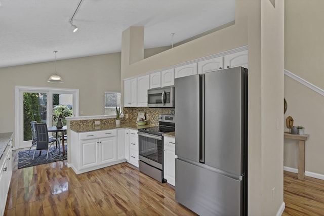 2375 Oakthorpe Dr, Hilliard, OH 43026 - kitchen with stainless steel appliances, white cabinets, a peninsula, vaulted ceiling, and light wood finished floors