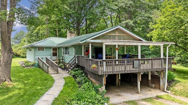 890 Elm Dr, Columbus, OH 43235 - view of front of property with a front lawn, a metal roof, a wooden deck, and a chimney