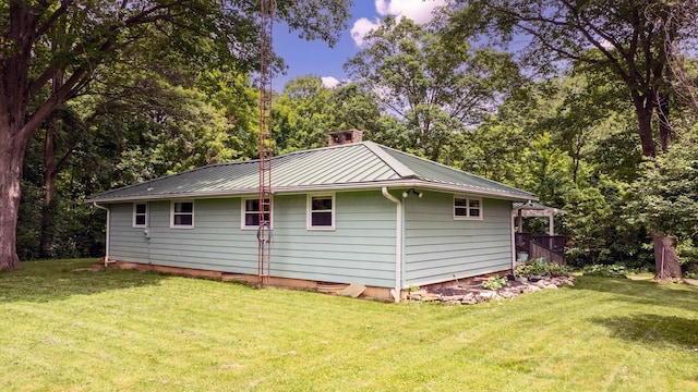 890 Elm Dr, Columbus, OH 43235 - view of side of property with a metal roof, a standing seam roof, a lawn, and view of wooded area