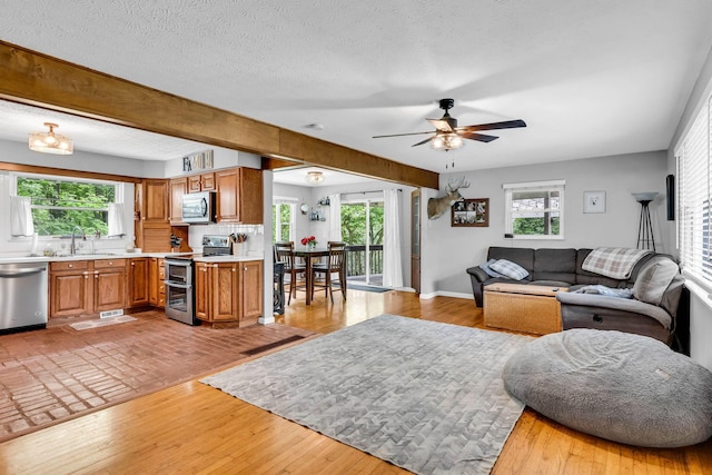 890 Elm Dr, Columbus, OH 43235 - living room featuring a ceiling fan, plenty of natural light, a textured ceiling, and light wood-style flooring