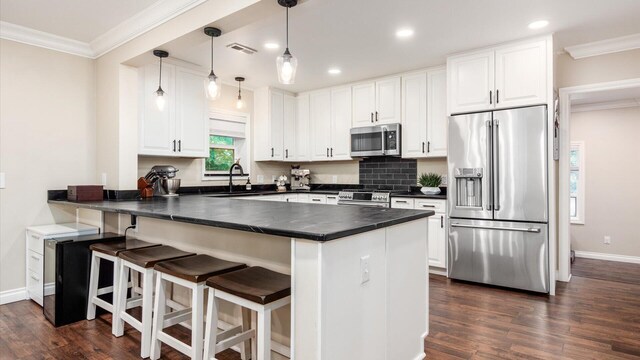 2830 Silver St, Granville, OH 43023 - kitchen featuring stainless steel appliances, dark countertops, a peninsula, white cabinets, and dark wood-type flooring