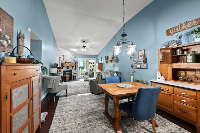 3903 Inverness Cir, Dublin, OH 43016 - dining space featuring ceiling fan, high vaulted ceiling, dark wood-type flooring, a stone fireplace, and a chandelier