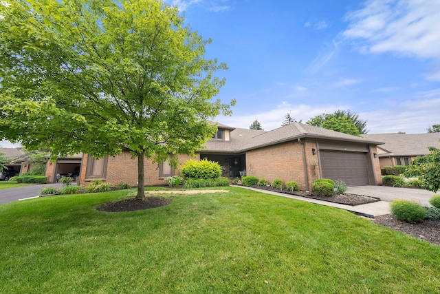 3903 Inverness Cir, Dublin, OH 43016 - view of property hidden behind natural elements featuring brick siding, a front lawn, a garage, and driveway