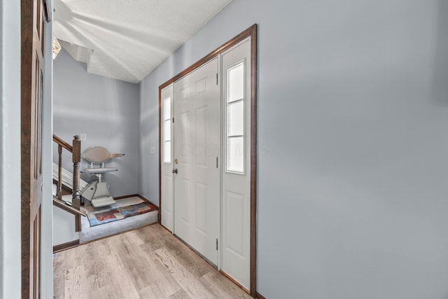 5681 Mcbride Ct, Dublin, OH 43016 - foyer entrance with light wood-style flooring, stairs, and a textured ceiling