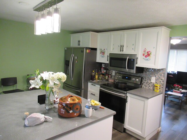 1881 Brimfield Rd, Columbus, OH 43229 - kitchen featuring stainless steel appliances, white cabinetry, light countertops, decorative backsplash, and hanging light fixtures
