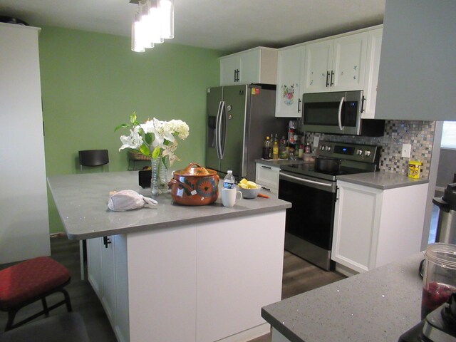 1881 Brimfield Rd, Columbus, OH 43229 - kitchen featuring stainless steel appliances, white cabinets, a center island, and decorative backsplash