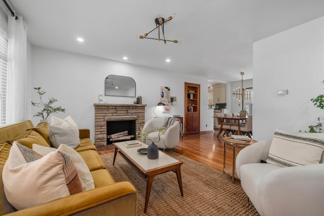 3287 Leighton Rd, Columbus, OH 43221 - living room featuring a chandelier, wood finished floors, recessed lighting, and a stone fireplace