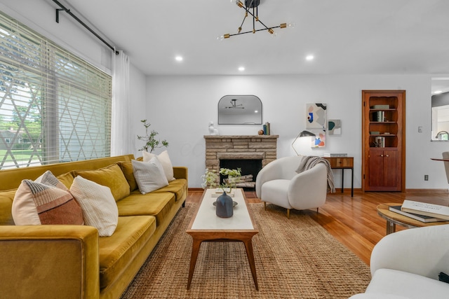 3287 Leighton Rd, Columbus, OH 43221 - living area featuring wood finished floors, a chandelier, recessed lighting, and a stone fireplace