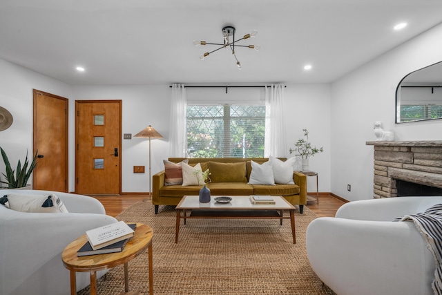 3287 Leighton Rd, Columbus, OH 43221 - living area featuring light wood finished floors, recessed lighting, a chandelier, and a stone fireplace