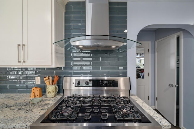 3287 Leighton Rd, Columbus, OH 43221 - kitchen with gas stove, wall chimney exhaust hood, tasteful backsplash, and arched walkways