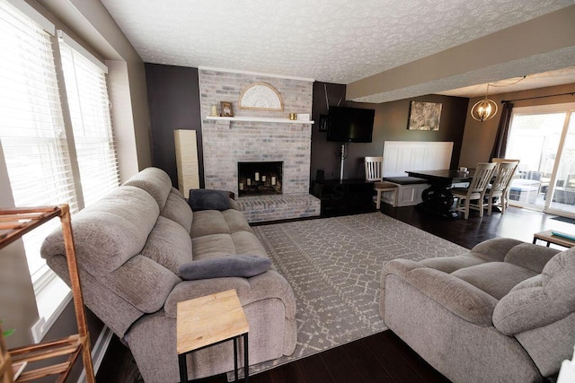 3790 Hunting Ln, Columbus, OH 43230 - living room with wood finished floors, a textured ceiling, and a brick fireplace