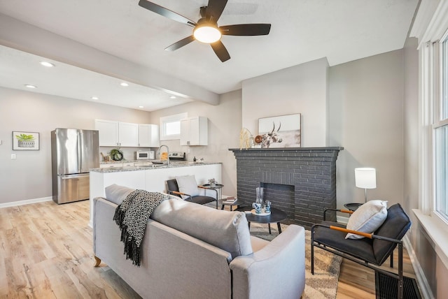 743 Reinhard Ave, Columbus, OH 43206 - living room with light wood-style floors, ceiling fan, a brick fireplace, and recessed lighting