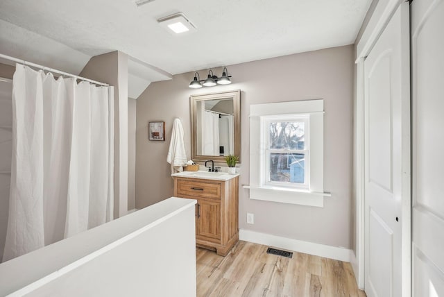 743 Reinhard Ave, Columbus, OH 43206 - bathroom with vanity, wood finished floors, lofted ceiling, and a shower with shower curtain