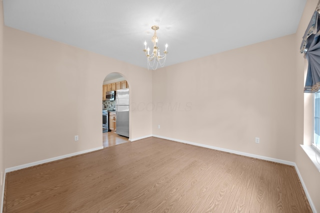 8101 Orange Station Loop, Lewis Center, OH 43035 - spare room with arched walkways, light wood-style flooring, and a chandelier