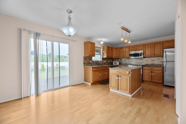 8101 Orange Station Loop, Lewis Center, OH 43035 - kitchen with stainless steel appliances, light wood-style floors, tasteful backsplash, and pendant lighting