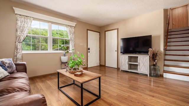 637 Livingston Ct, Heath, OH 43056 - living room featuring stairway, light wood-type flooring, and a textured ceiling