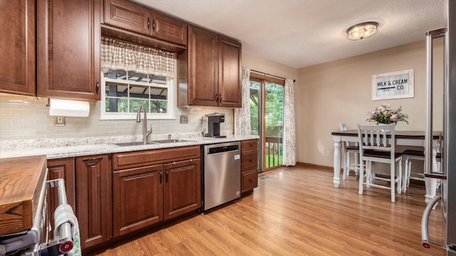 637 Livingston Ct, Heath, OH 43056 - kitchen featuring dishwasher, light wood-style flooring, backsplash, light stone counters, and a textured ceiling