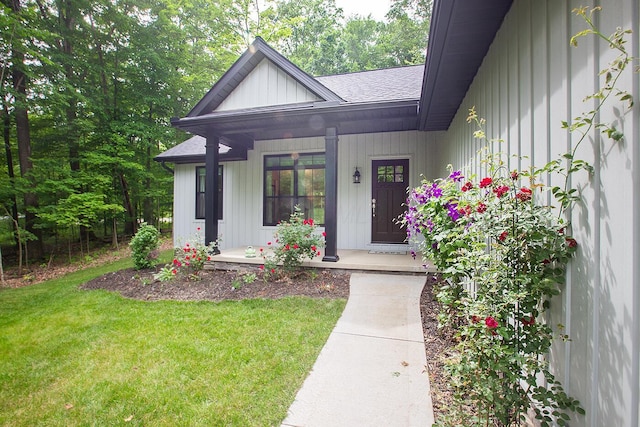 2499 Apple Valley Dr, Howard, OH 43028 - view of exterior entry featuring covered porch, a yard, a shingled roof, and board and batten siding