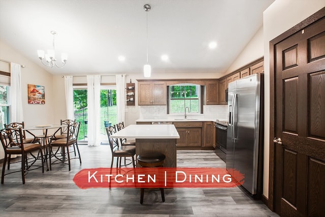 2499 Apple Valley Dr, Howard, OH 43028 - kitchen with stainless steel fridge, lofted ceiling, stove, decorative backsplash, and light countertops