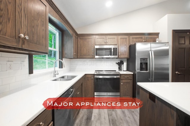 2499 Apple Valley Dr, Howard, OH 43028 - kitchen with stainless steel appliances, vaulted ceiling, light countertops, tasteful backsplash, and wood finished floors