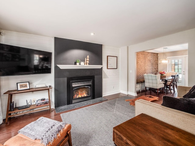 1243 Harrison Ave, Columbus, OH 43201 - living room with wood finished floors, a large fireplace, and a chandelier