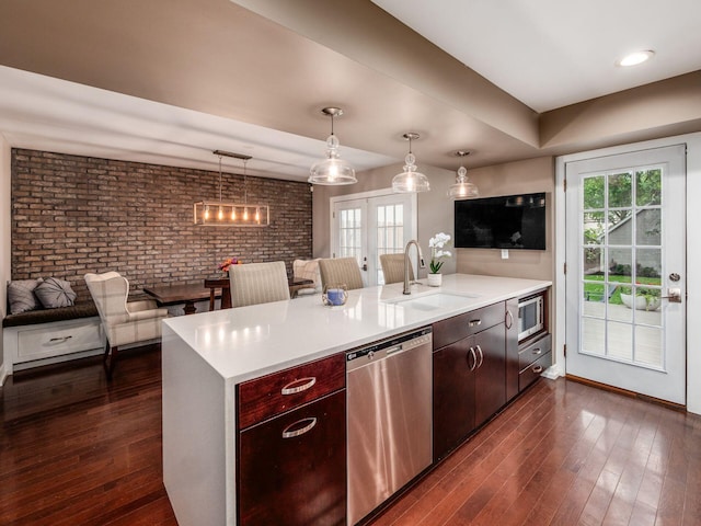 1243 Harrison Ave, Columbus, OH 43201 - kitchen with appliances with stainless steel finishes, brick wall, plenty of natural light, a peninsula, and light countertops