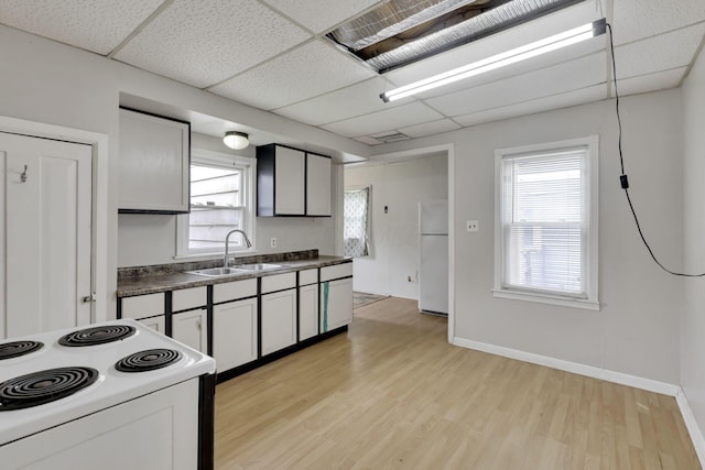 846 4th St, Lancaster, OH 43130 - kitchen with white appliances, light wood-style floors, dark countertops, a paneled ceiling, and healthy amount of natural light